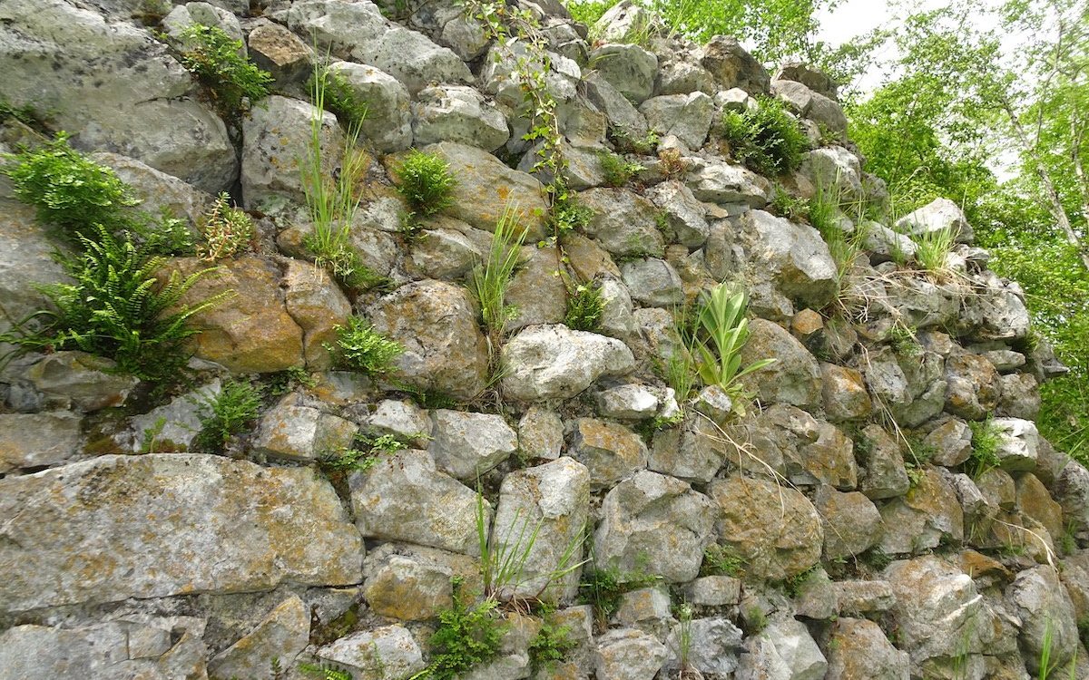 Eine Trockenmauer aus Natursteinen bei der mittelalterlichen Burg Weissenau bei Interlaken im Berner Oberland. 