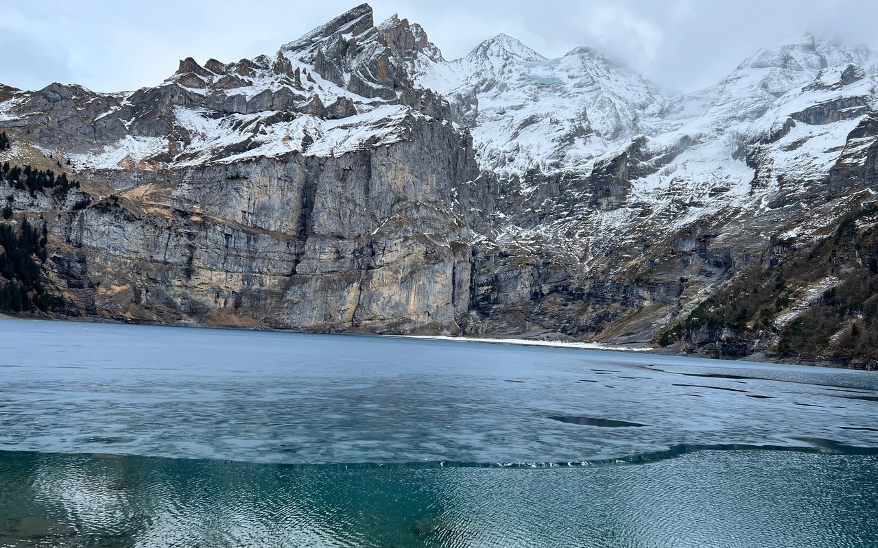 Der malerische Oeschinensee in den Alpen friert bei extremen Kälteperioden vollständig zu und bietet mit seinem spektakulären Schwarzeis eine perfekte Kulisse zum Schlittschuhlaufen.